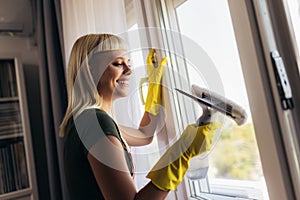 Young woman cleaning windows