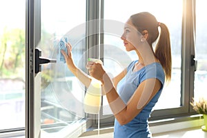 Woman cleaning windows at home