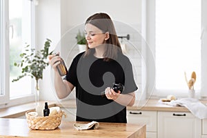 Young woman cleans the kitchen with eco products.