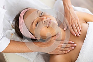 Young woman client gets procedure of rejuvenating decollete and neck massage