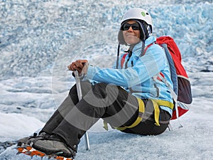 Young woman climber resting on top of a glacier