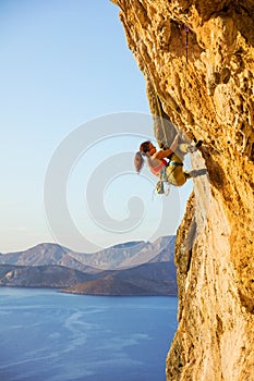 Young woman climbing challenging route