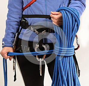 Young woman in climbing equipment on white background