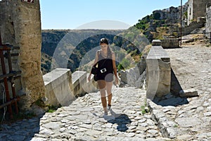 Young woman climbing a flight of steps in the old town of Matera, UNESCO World Heritage Site and European Capital of Culture 2019.
