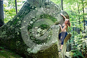 Young woman climbing on large boulders outdoor