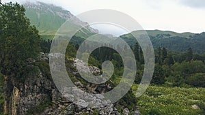 Young woman climbing on mountain aerial view. Drone view woman on stony cliff