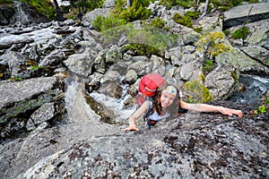 Young woman is climbing at stone whike trekking in highlands of