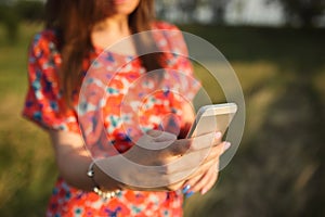 Young woman close-up in red dress using mobile smart phone