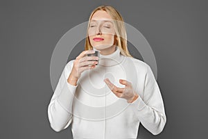 Young woman with closed eyes inhales the aroma of fresh coffee