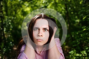 Young woman closing ears.