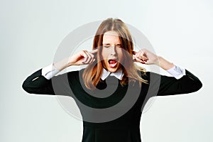 Young woman closing her ears and screaming