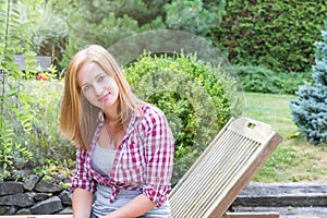 Young woman clothed in checkered shirt is posing