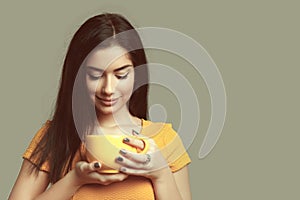 Young woman with coffee cup isolated on gray