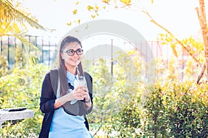 Young woman with coffee in garden