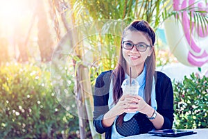 Young woman with coffee in garden