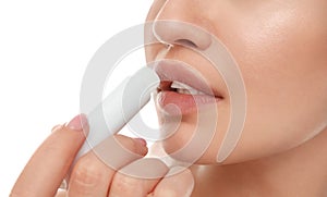 Young woman with cold sore applying lip balm against background, closeup