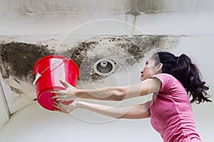 Young woman collecting drops rainwater