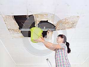 Young Woman Collecting Water In Bucket From Ceiling. Ceiling pan