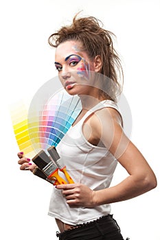 Young woman with a color guide and paintbrushes.