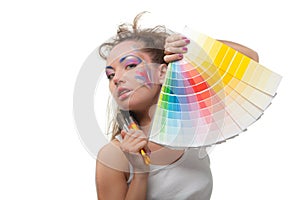 Young woman with a color guide and paintbrushes.