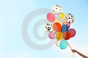 Young woman with colorful balloons outdoors