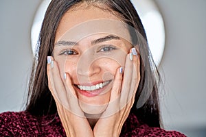 Young woman with colourful manicure nails looking at camera and smiling.