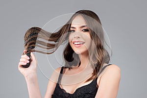 Young woman combing healthy and natural shiny hair,  on studio. Beauty hair care.