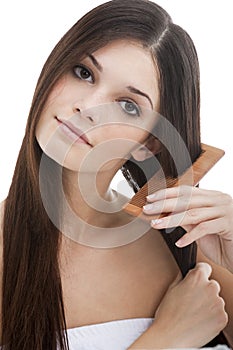 Young woman combing her hair