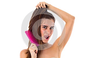 Young woman combing her long ponytail