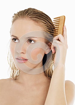 Young Woman Combing Her Wet Blond Hair