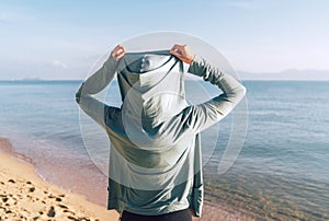 Young woman in comfort sport hoodie clothes watching on the sea horizon