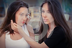 Young woman comforting tearful friend