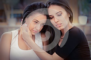 Young woman comforting tearful friend