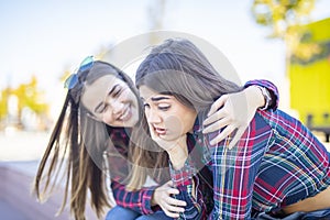 Young woman comforts a sad female friend