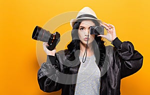Young woman comparing professional and compact cameras