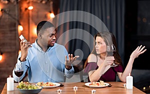 Young Woman Complaining About Her Boyfriend Talking On Cellphone During Romantic Date