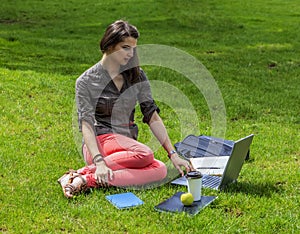 Young Woman with Computer in an Urban Park