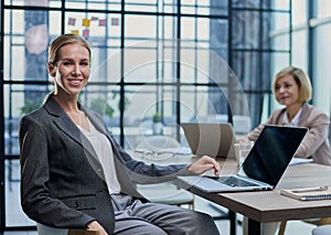 Young woman with computers at desk in office photo