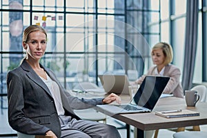 Young woman with computers at desk in office photo