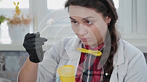 Young woman conducting chemical experiments at home.