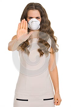 Young woman in cone mask showing stop gesture