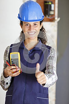 young woman with construction site helmet showing thumbs up