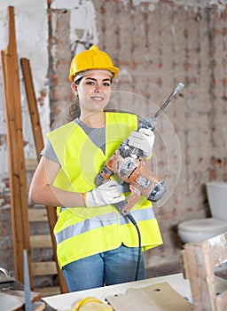 Young woman construction worker standing inside apartment