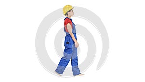 Young woman construction worker in yellow hardhat walking on whi