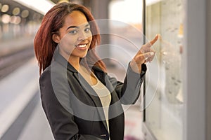 Young woman consulting a train timetable