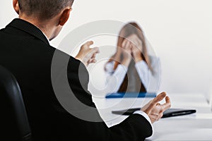 Young woman during a conversation with the boss who points out her mistakes