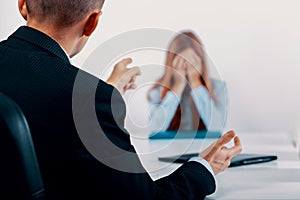 Young woman during a conversation with the boss who points out her mistakes