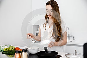 A young woman cook with vegetables.