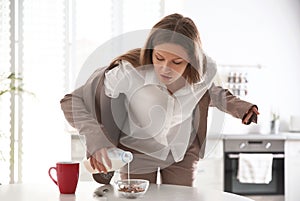 Young woman cooking breakfast in hurry at home