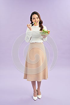 Young Woman Cooking and eating healthy Food - Vegetable Salad. Diet. Dieting Concept